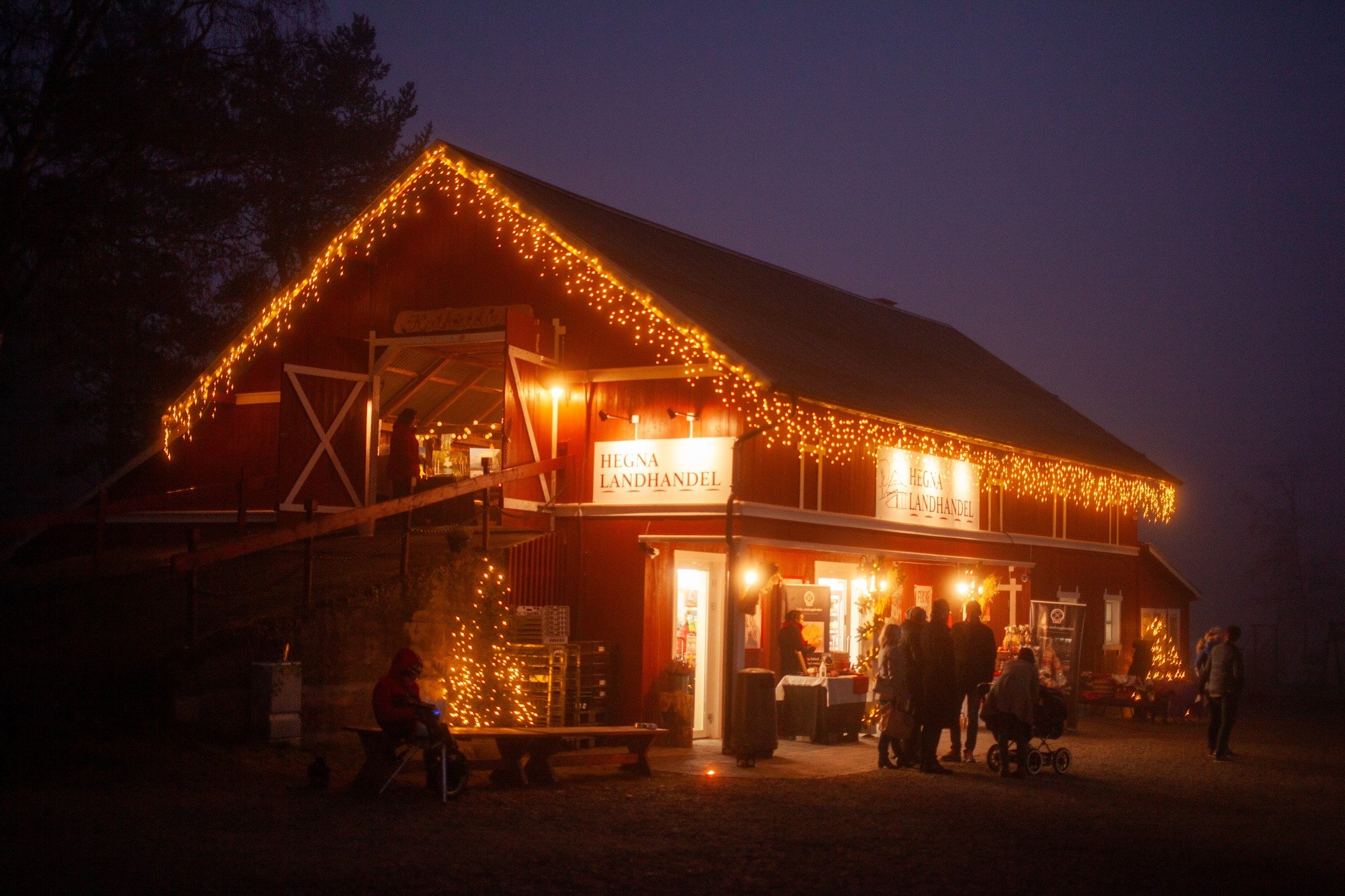 Koselig landhandel dekorert med lys i kveldsmørket.