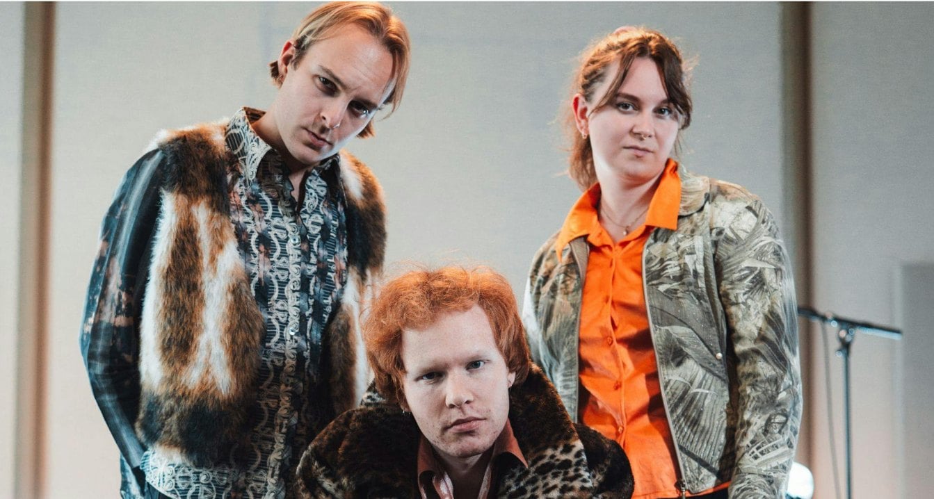 Jeg vet ikke hvem dette er, men her er et forslag til alt-tekst:Tre personer poserer i fargerike mønstrede klær.