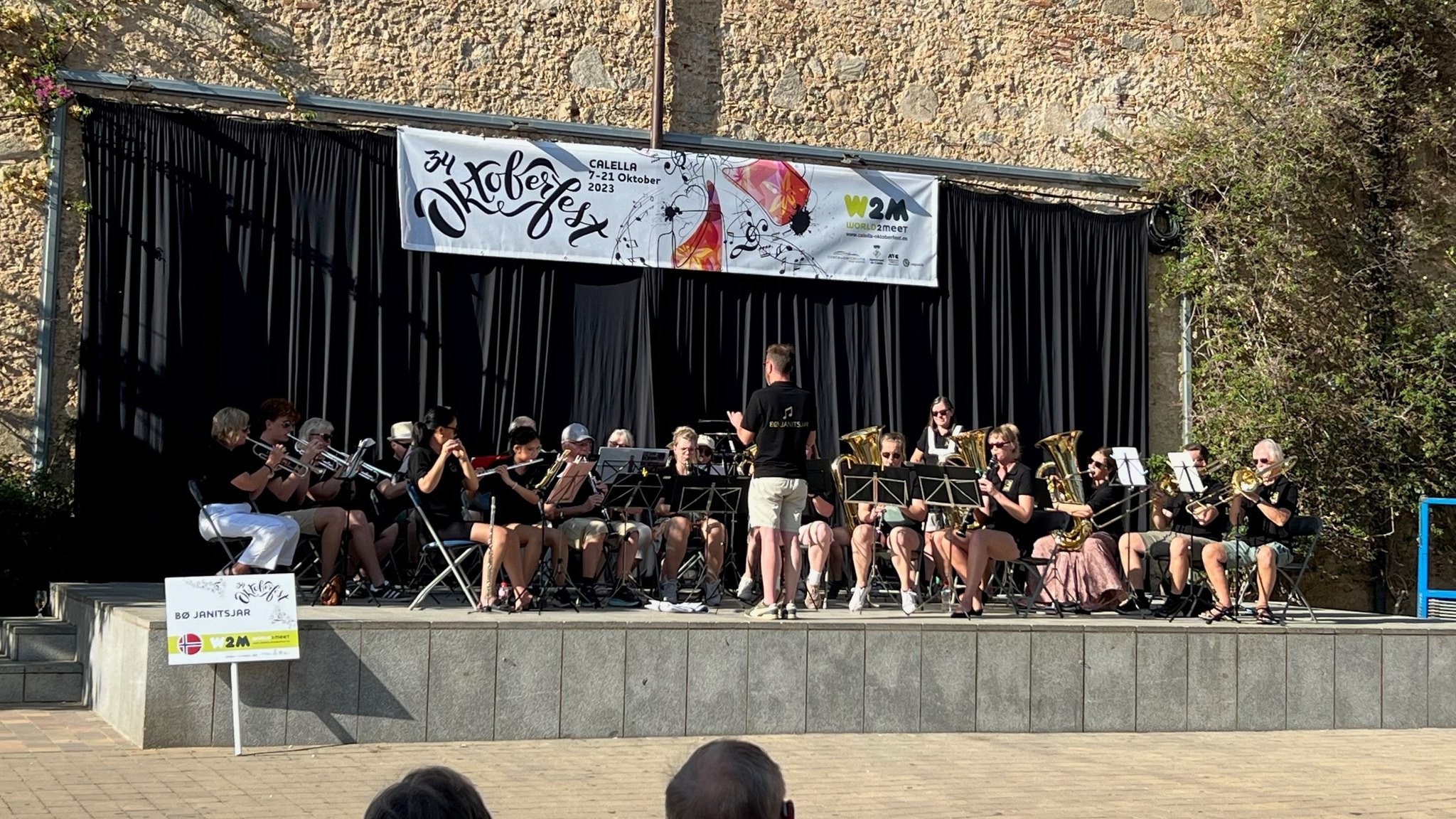 Et orkester opptrer på en utendørsscene under Oktoberfest-arrangementet i Calella 2023.