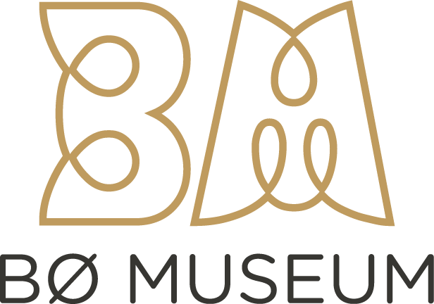 Alt-tekst: Bø Museum sin stiliserte logo med bokstavene B og M i gullfarge, symboliserer kultur og historie.